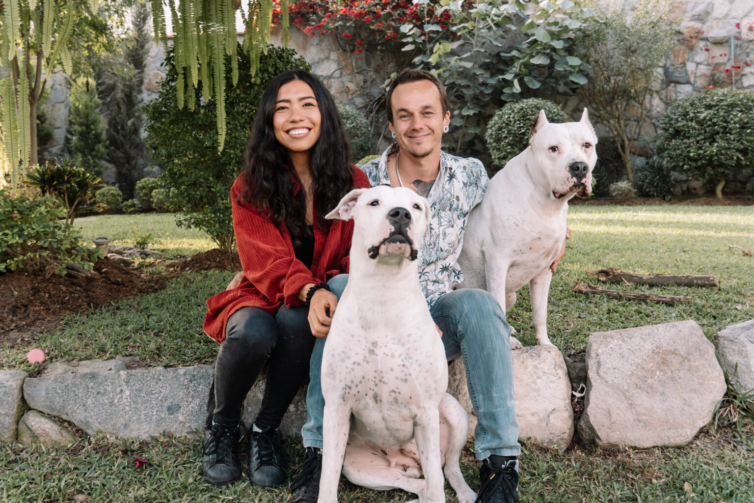 Valeria Ayvar y Robert Llorente junto a dos de sus perros en el jardín